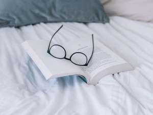 Glasses and book on bed